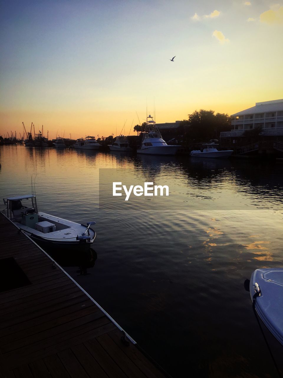 BOATS IN LAKE AT SUNSET