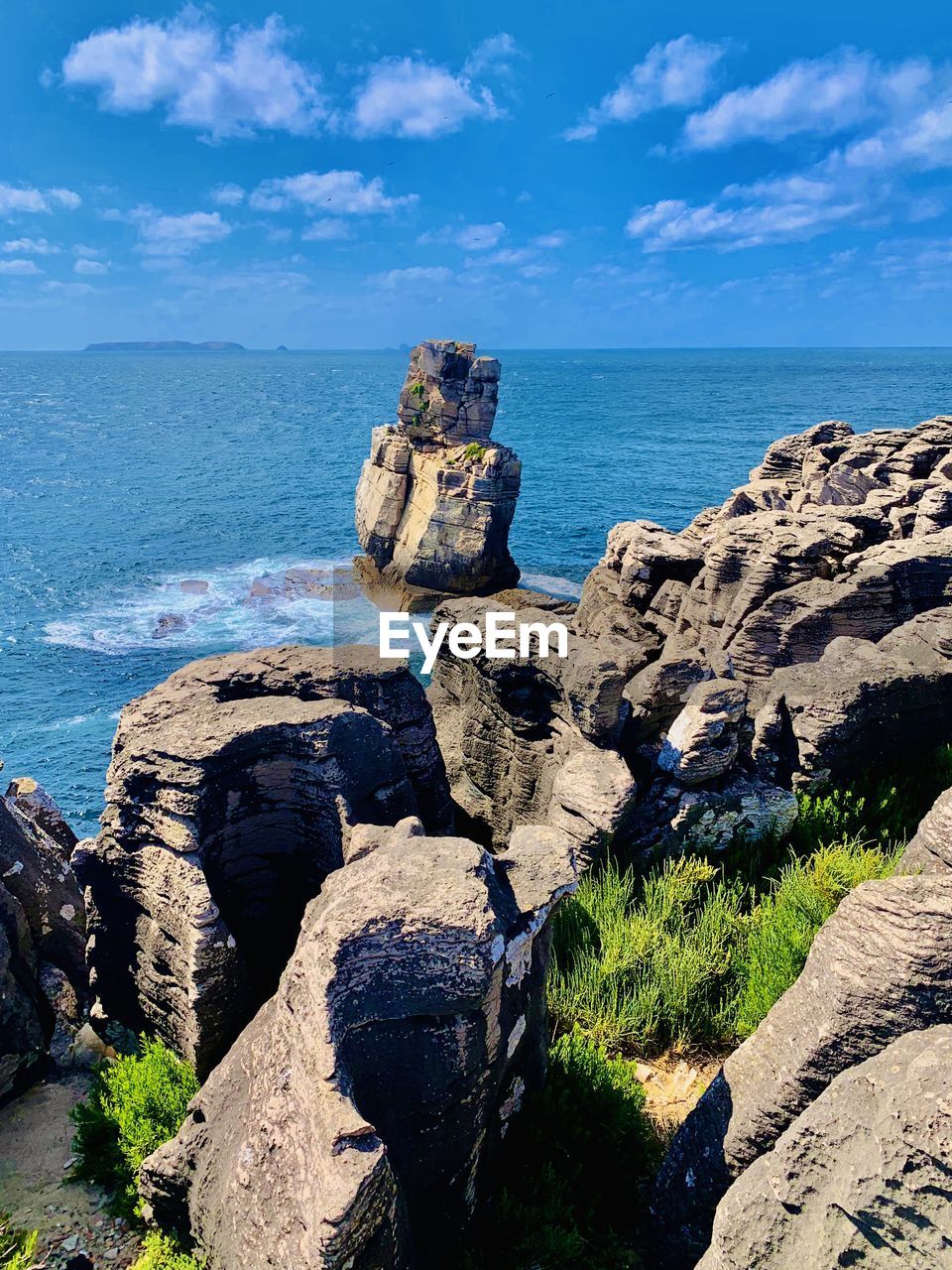 ROCK FORMATIONS ON SHORE AGAINST SKY