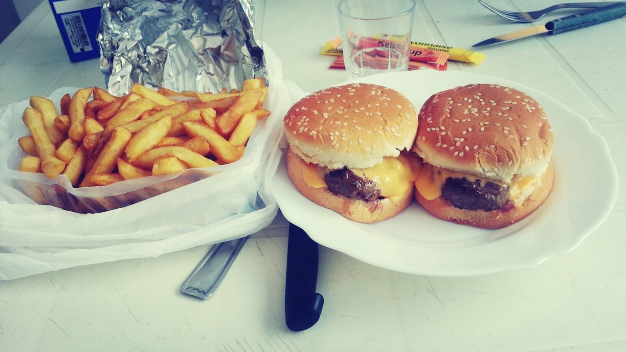 Close-up of french fries and burger on table