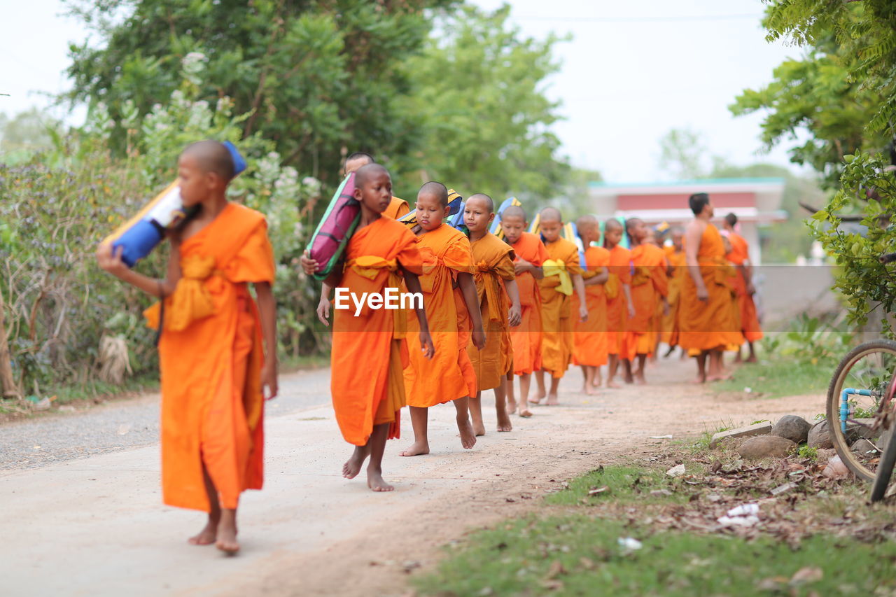 GROUP OF PEOPLE WALKING IN ROW