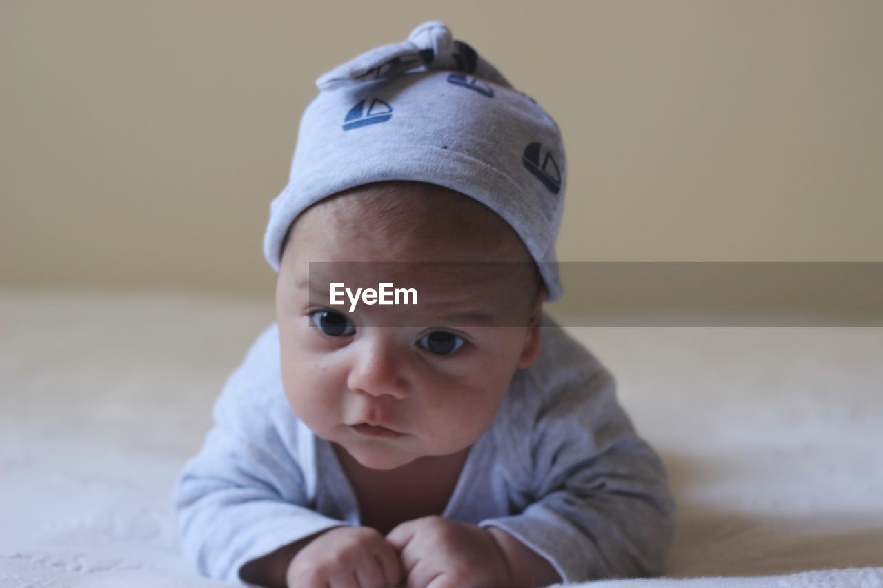 Cute baby boy lying on bed at home