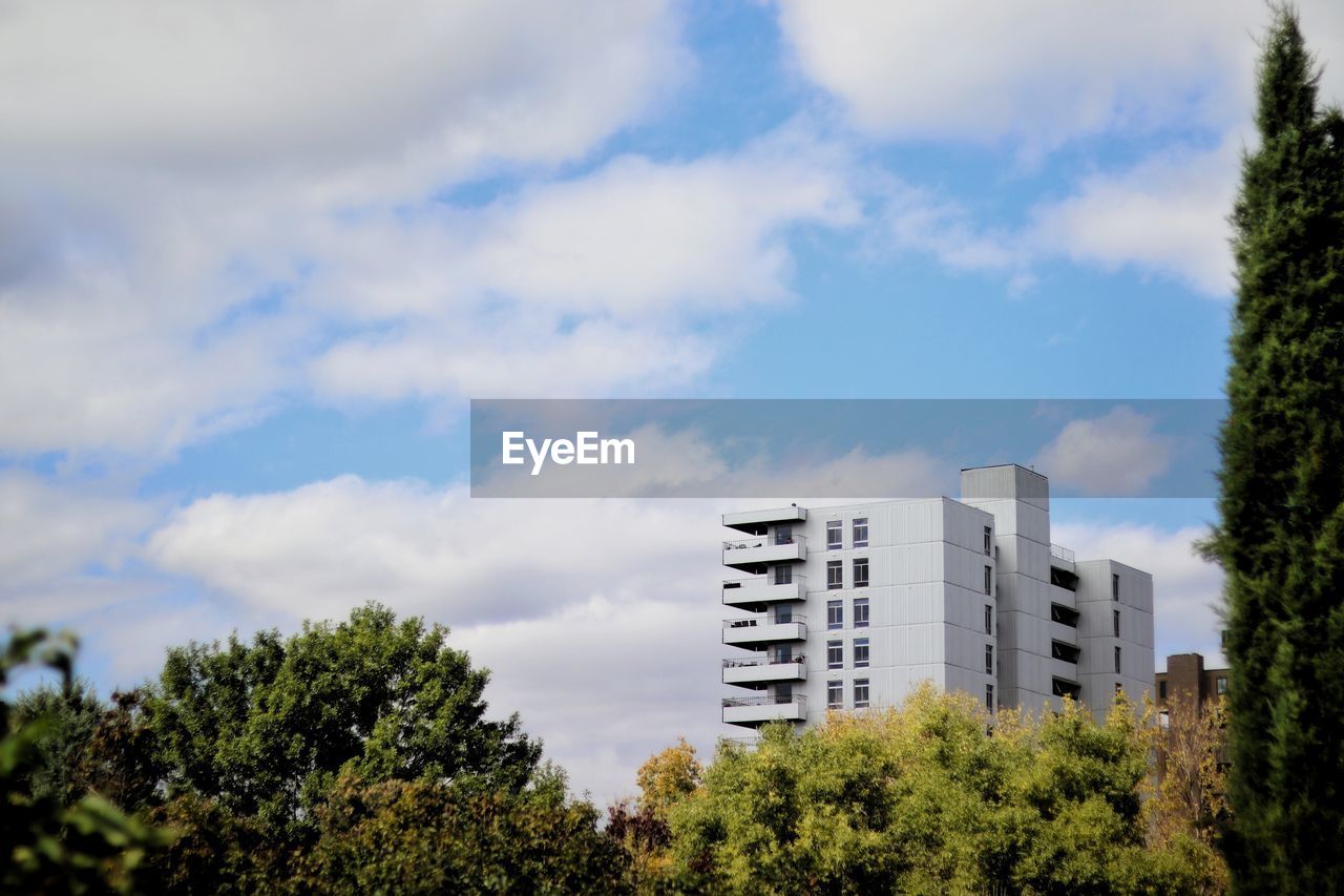 Low angle view of trees and buildings against sky