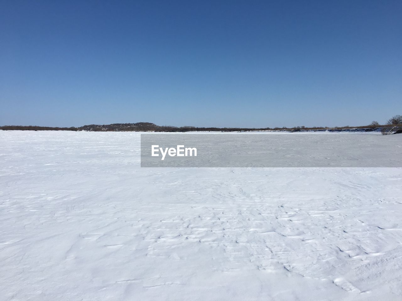 FROZEN LANDSCAPE AGAINST CLEAR BLUE SKY