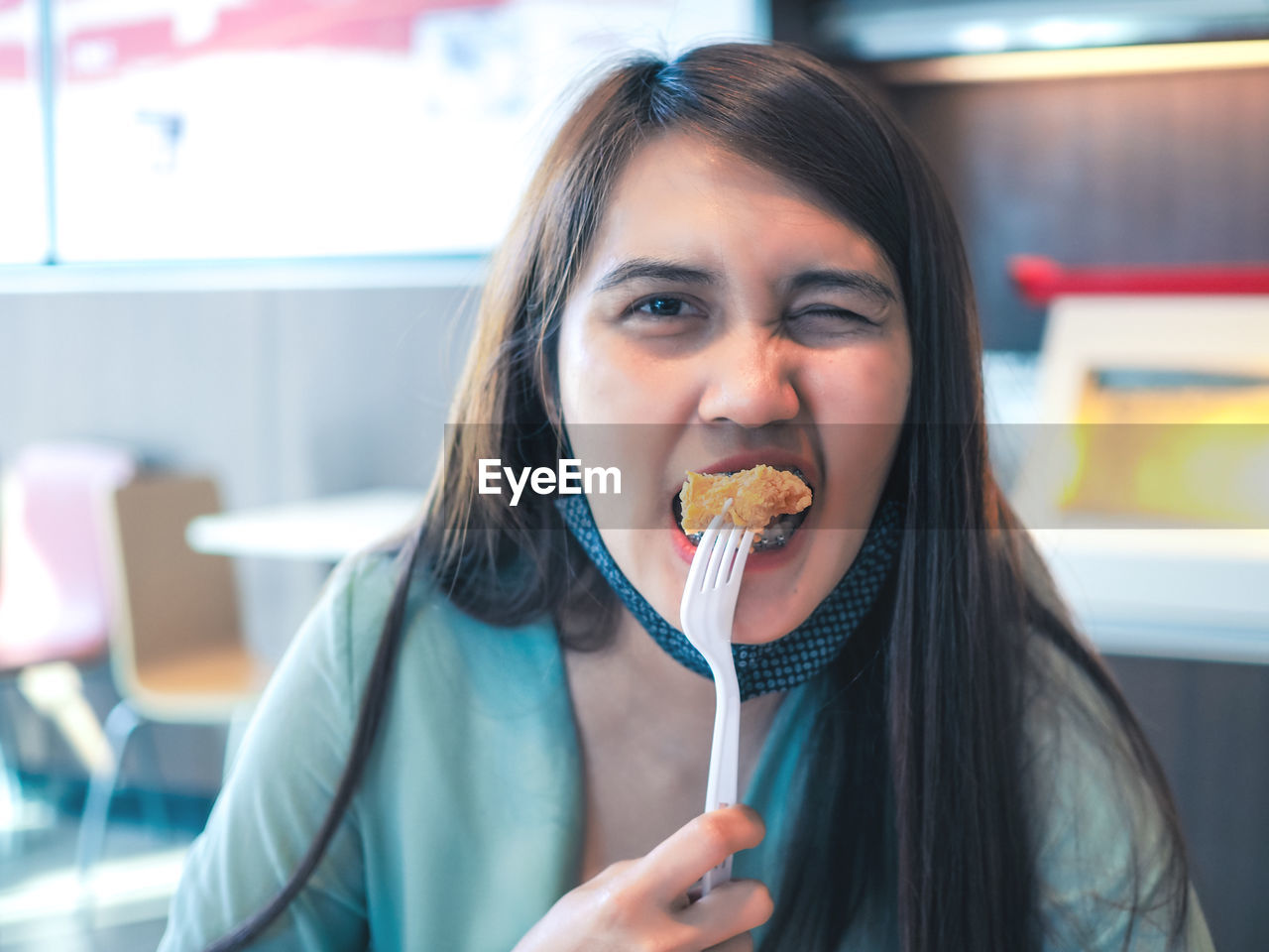 Portrait of woman eating food at restaurant