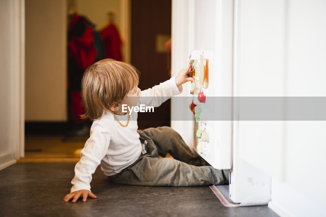 Boy playing with fridge magnets
