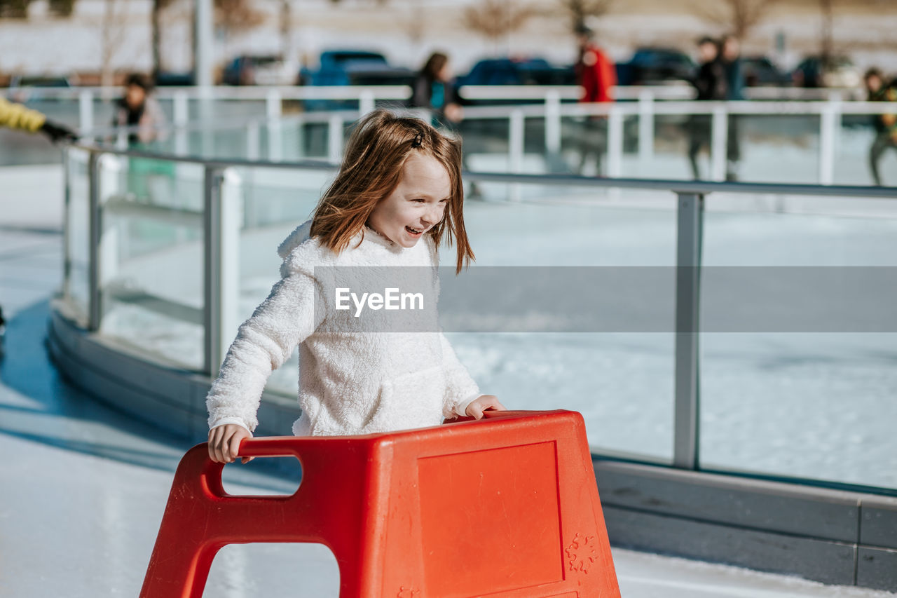 Young girl learning how to ice skate on a sunny winter day