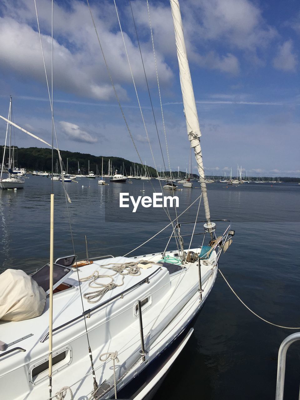 Sailboats moored in sea against sky