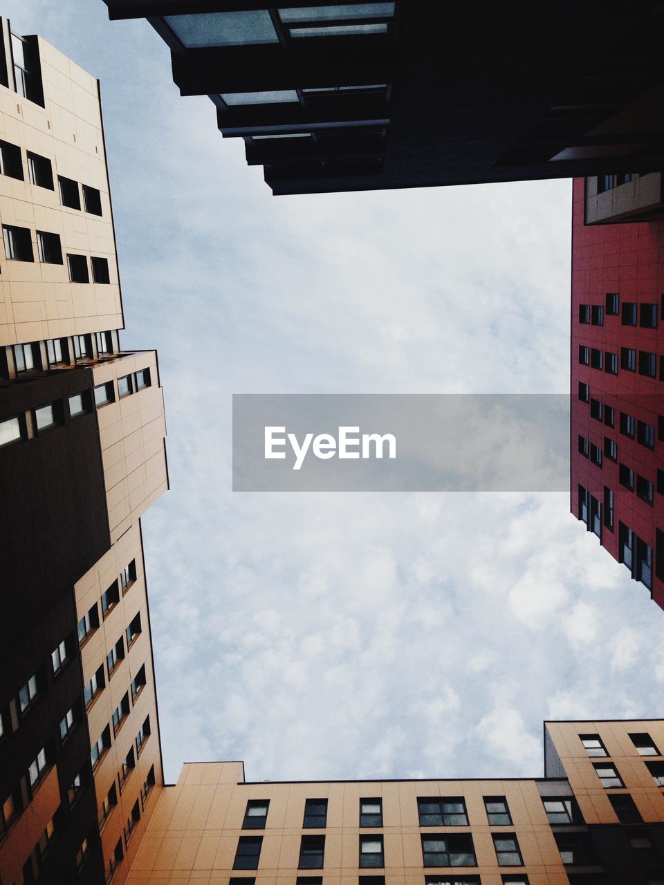 Low angle view of buildings against cloudy sky