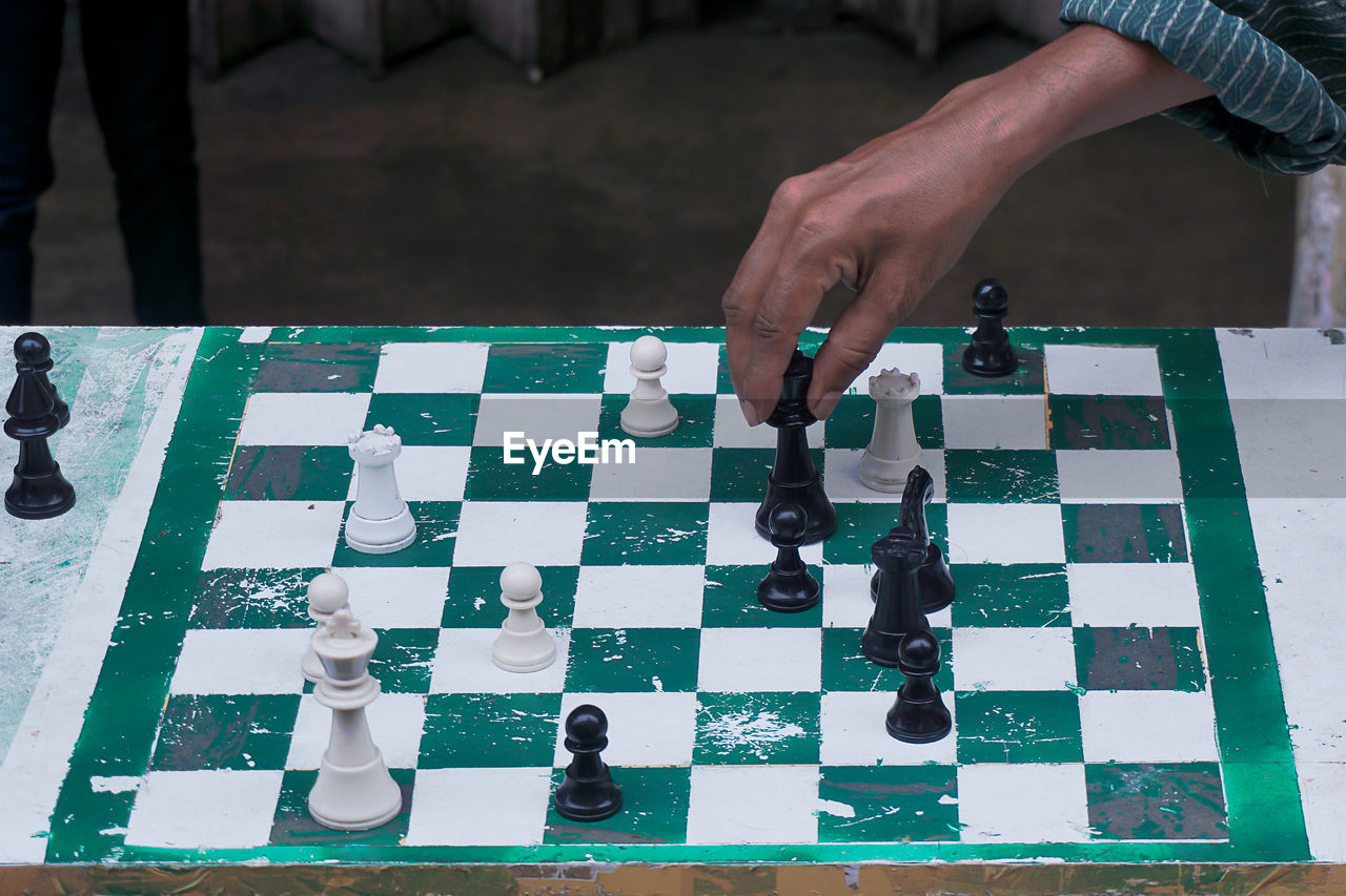 HIGH ANGLE VIEW OF BABY PLAYING WITH CHESS