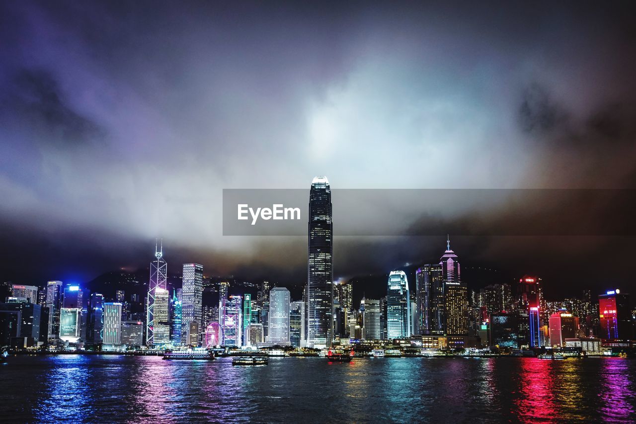 Illuminated buildings in city against sky at night