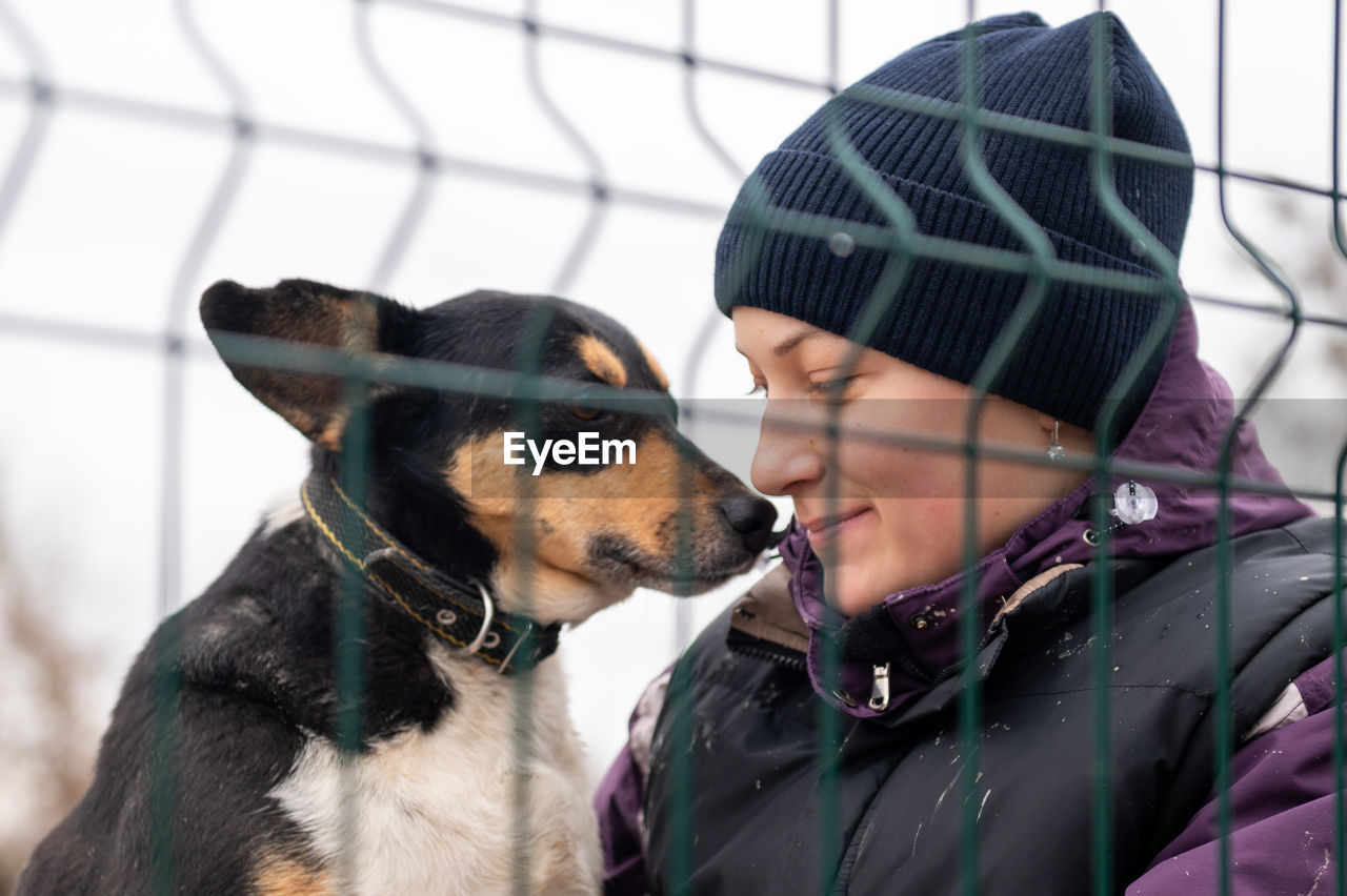 Volunteer in the nursery for dogs. woman volunteer in a cage with a stray dog at an animal shelter