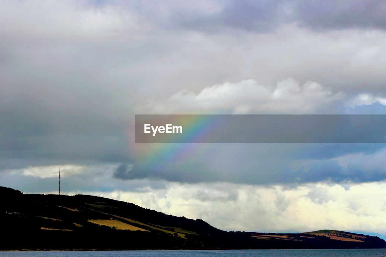 SCENIC VIEW OF RAINBOW OVER MOUNTAIN AGAINST SKY