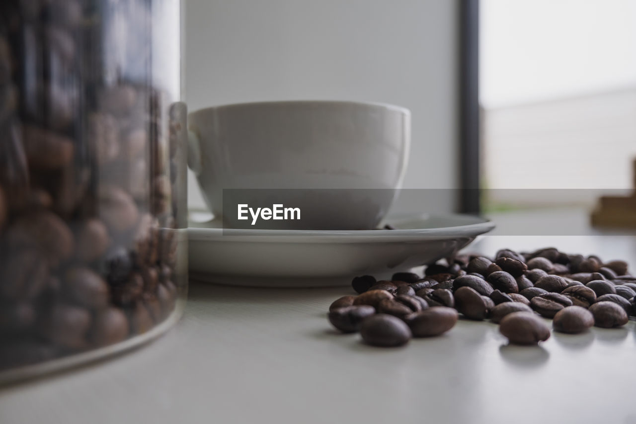 CLOSE-UP OF COFFEE BEANS IN GLASS ON TABLE