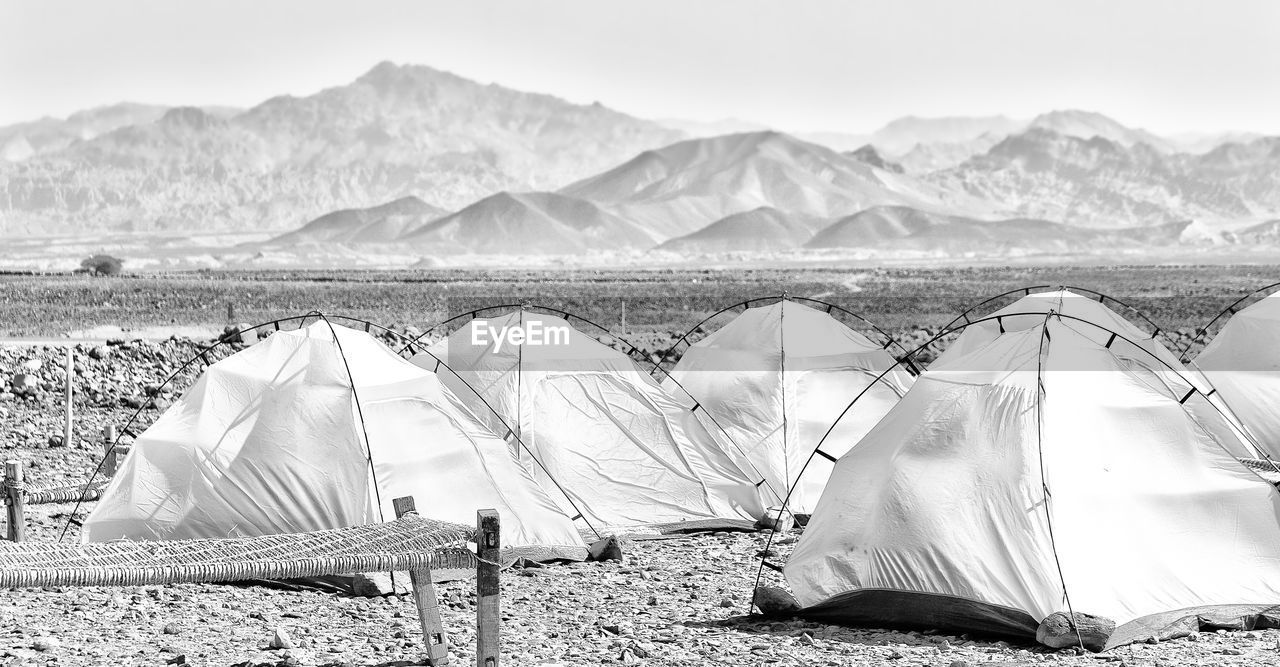 TENT ON BEACH AGAINST MOUNTAINS