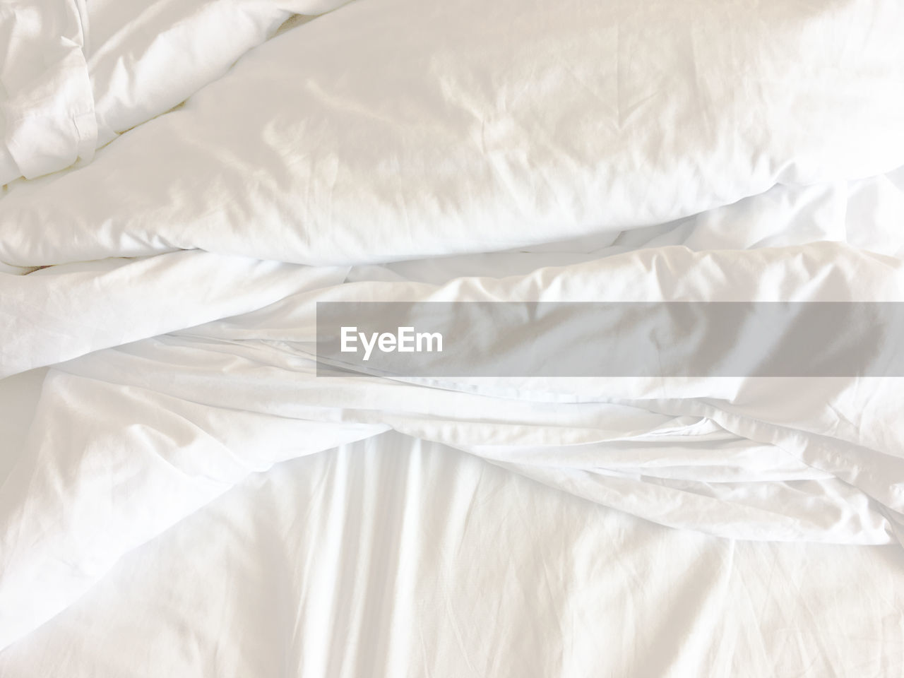 HIGH ANGLE VIEW OF WHITE BED ON BLANKET