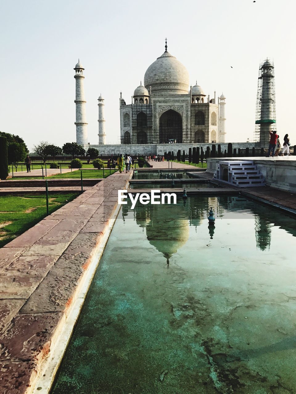 REFLECTION OF BUILDINGS IN WATER AGAINST CLEAR SKY