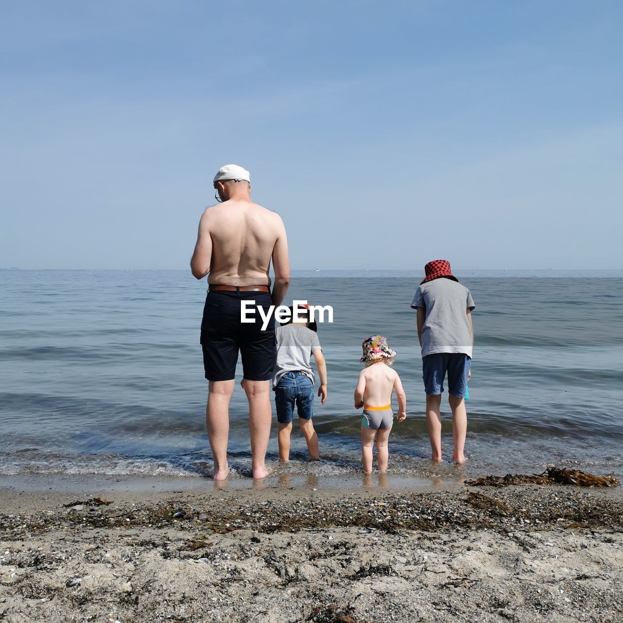 Father with three sons on the beach.