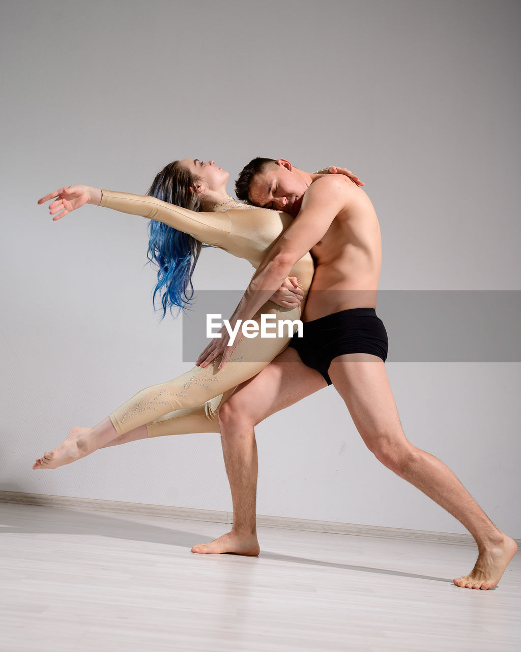 Young couple kissing against white background