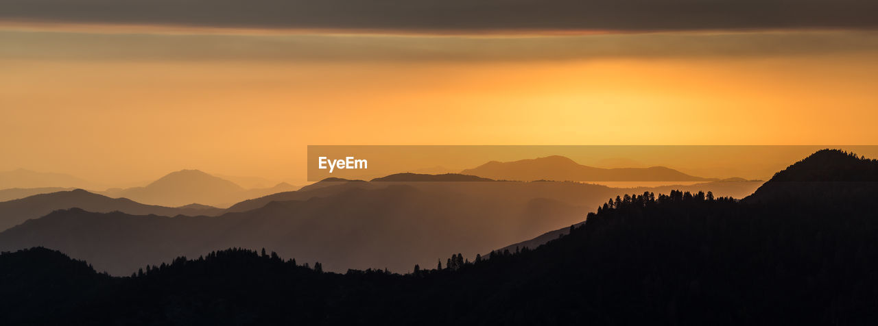 Scenic view of silhouette mountains against sky at sunset