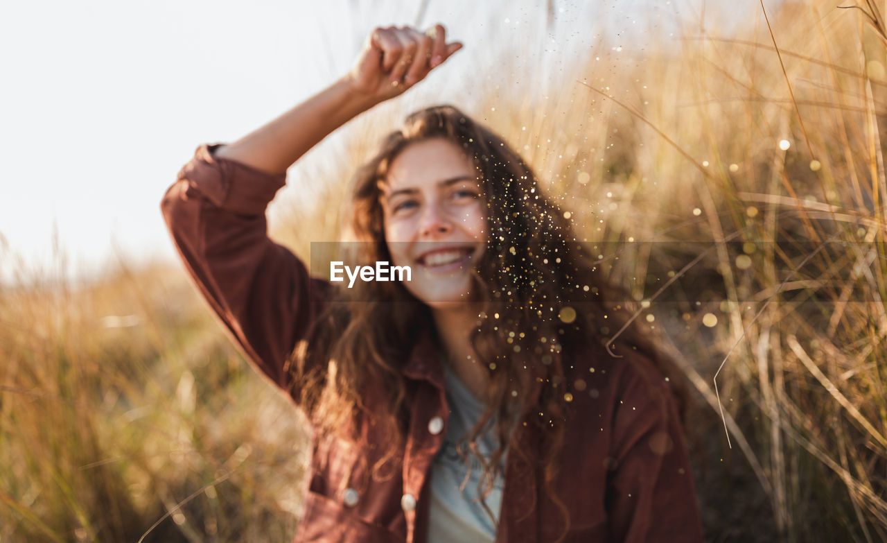 Smiling young woman holding glitter