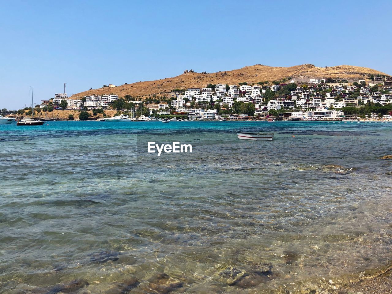 SCENIC VIEW OF SEA AND BUILDINGS AGAINST CLEAR SKY