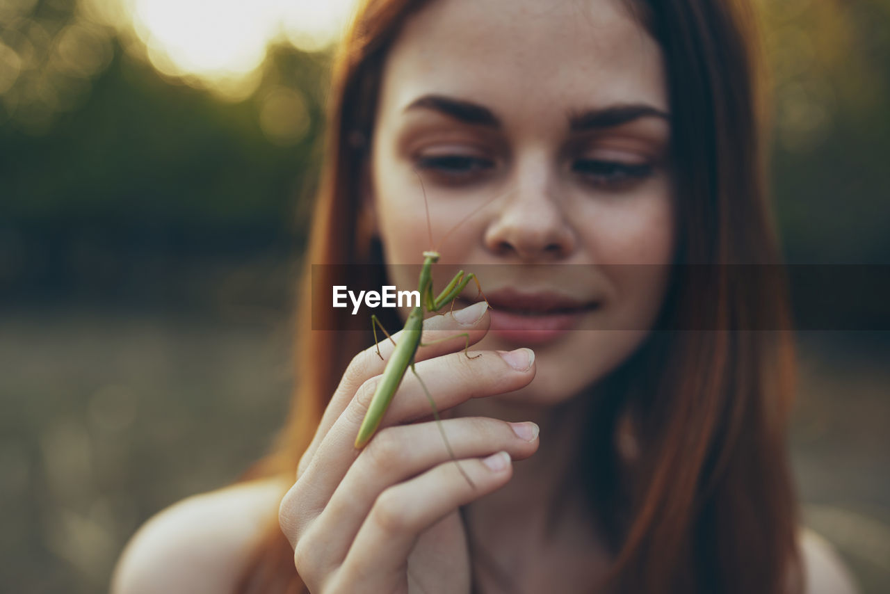 Portrait of young woman holding plant