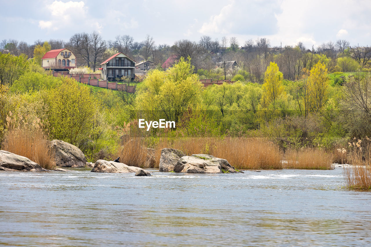 river, water, tree, nature, plant, architecture, built structure, sky, shore, environment, no people, body of water, cloud, land, landscape, day, scenics - nature, outdoors, travel, travel destinations, beauty in nature, autumn, building exterior, forest, building, reservoir, waterway, transportation