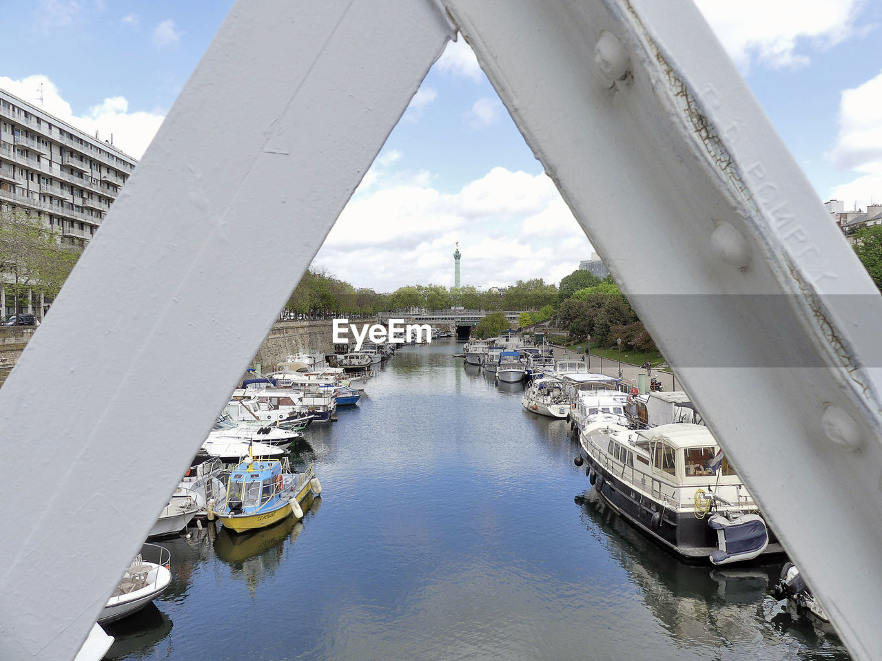 Bridge over river in city against sky