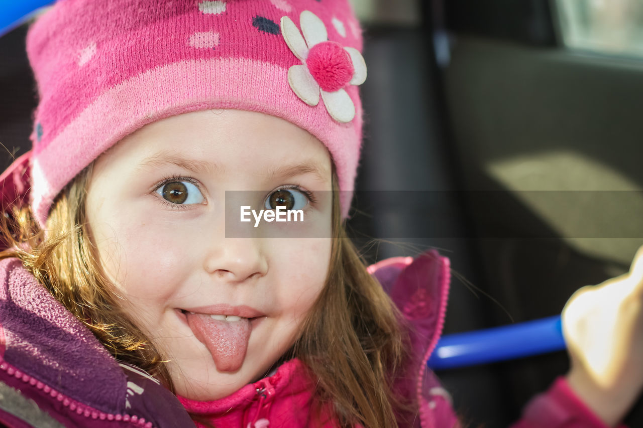 Portrait of happy child. little girl shows her tongue. little cute girl sticking her tongue out.