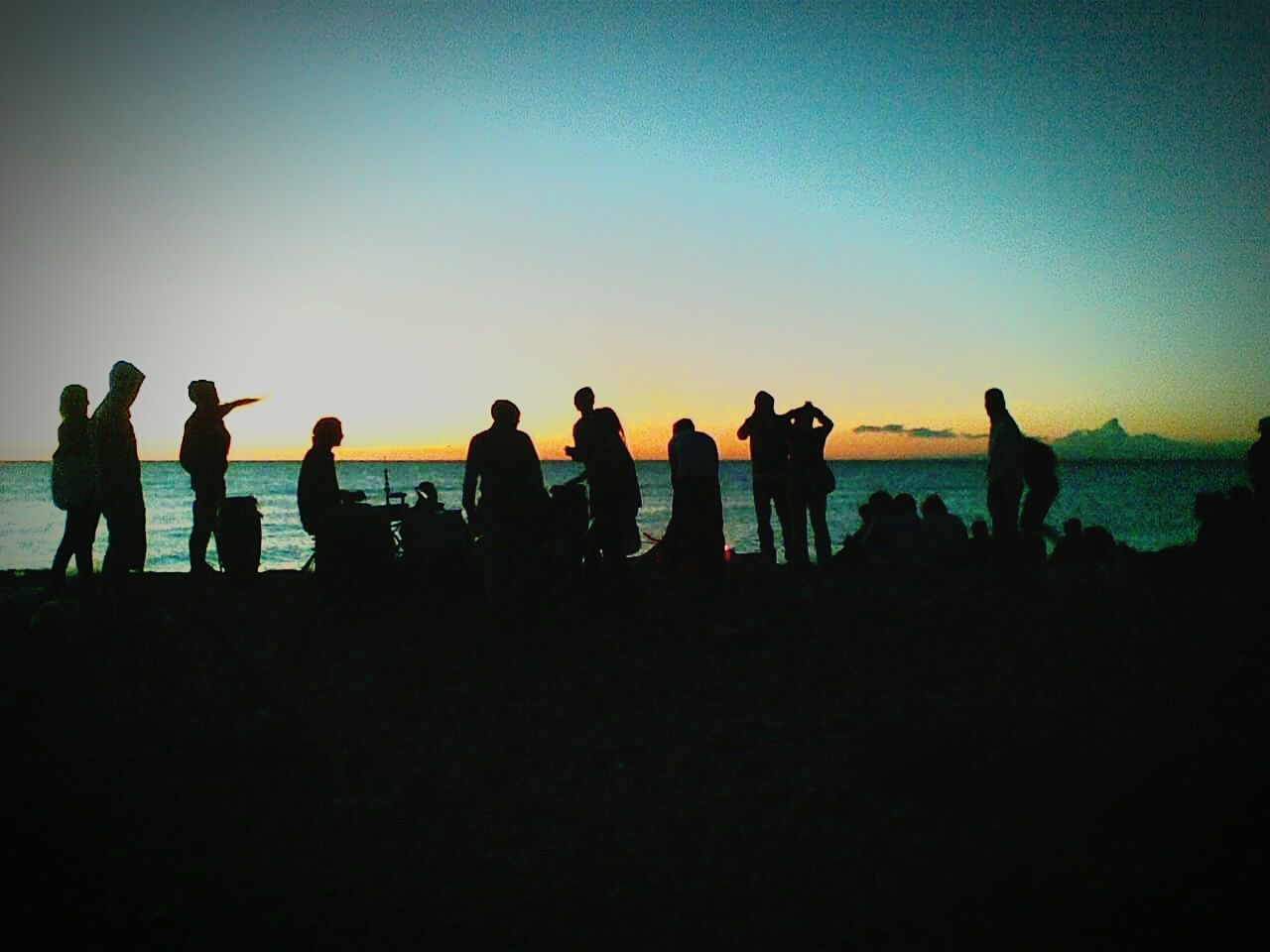 Silhouette of people on beach at sunset