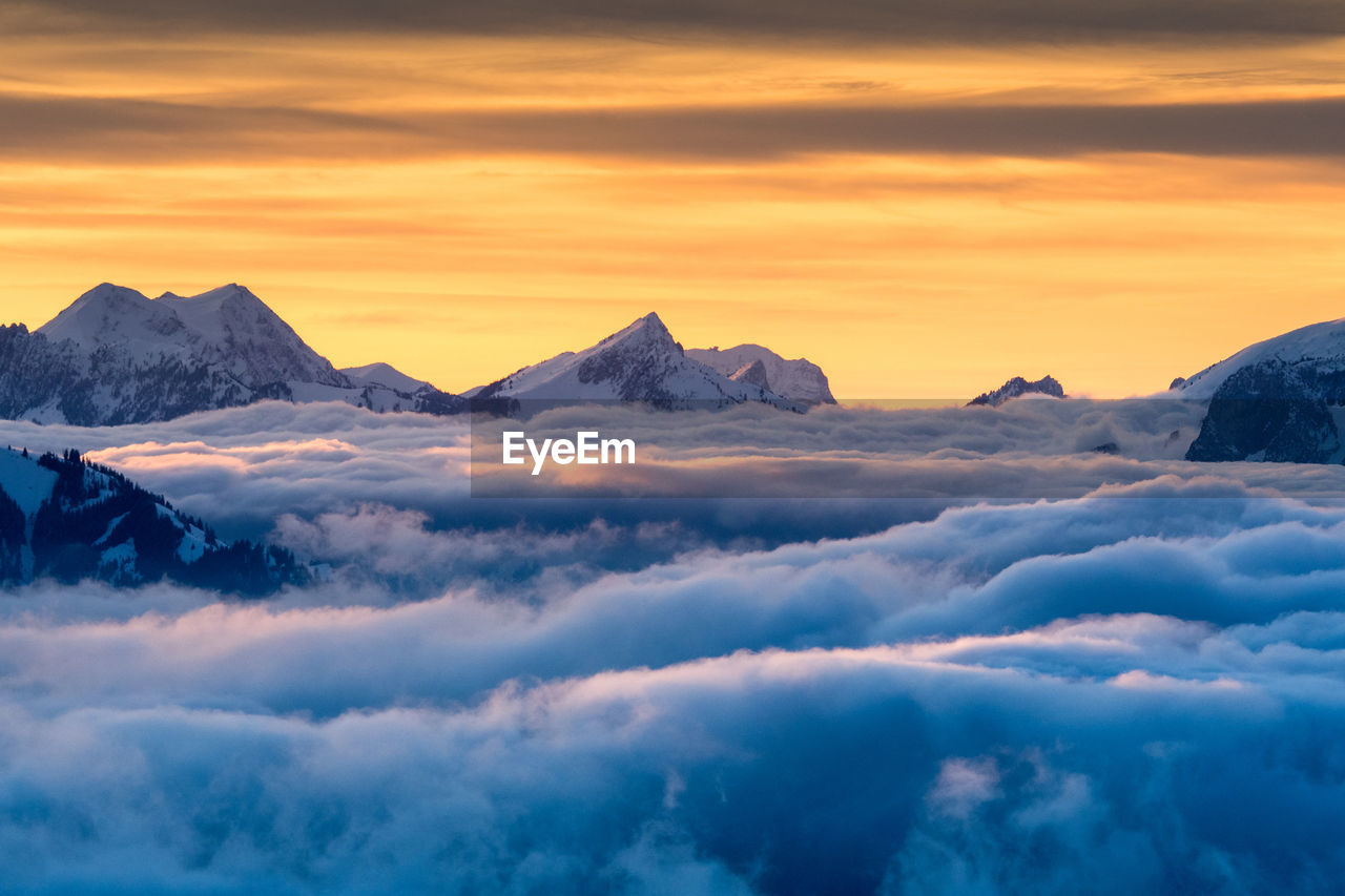 Scenic view of snowcapped mountains against sky during sunset