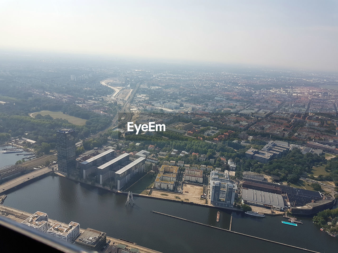 HIGH ANGLE VIEW OF RIVER BY BUILDINGS AGAINST SKY