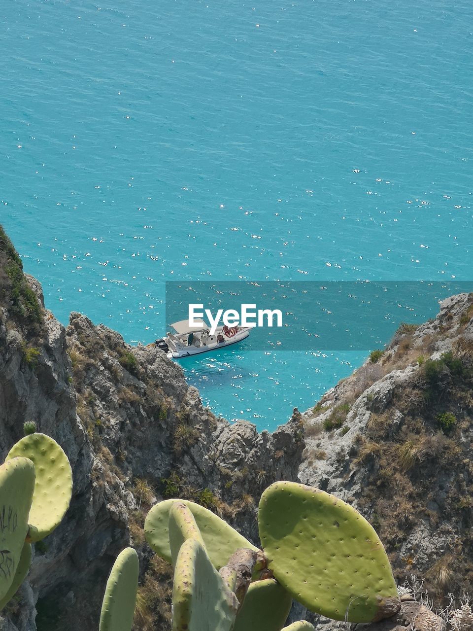 HIGH ANGLE VIEW OF WOMAN SWIMMING ON ROCKS