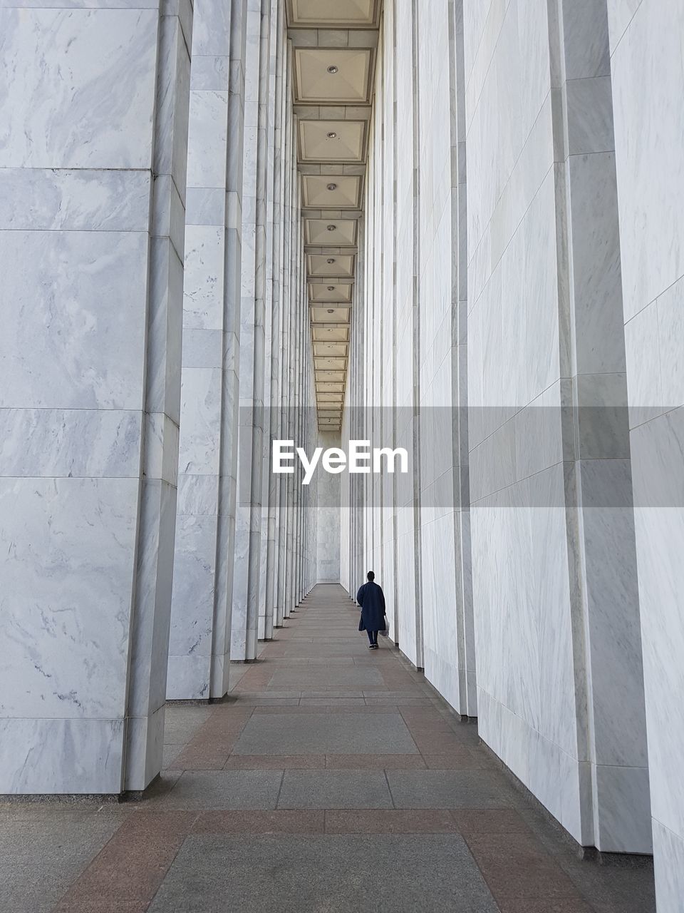 REAR VIEW OF PEOPLE WALKING IN BUILDING