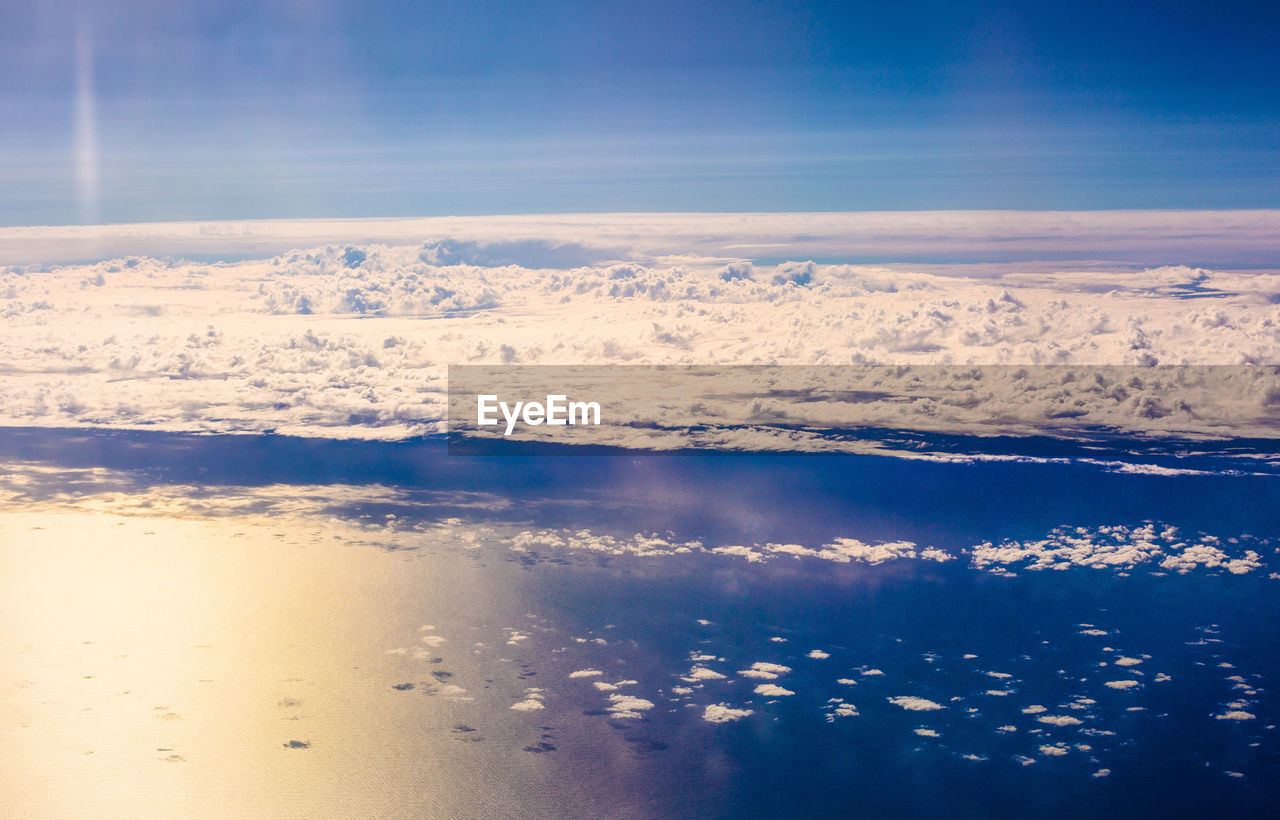 Clouds hovering above the vast reflective ocean waters below - queenstown, new zealand