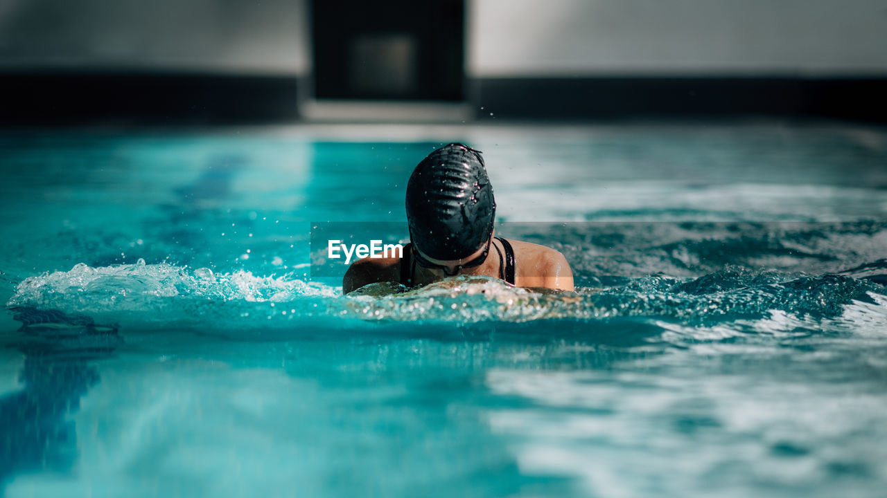 Woman swimming in the swimming pool.