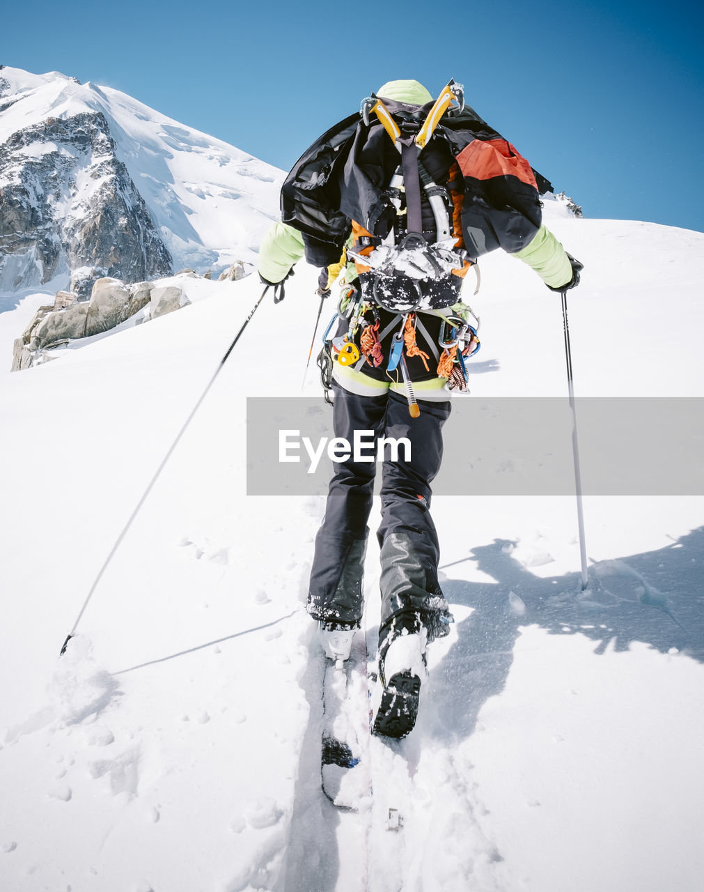 Rear view of person skiing on snow covered mountain