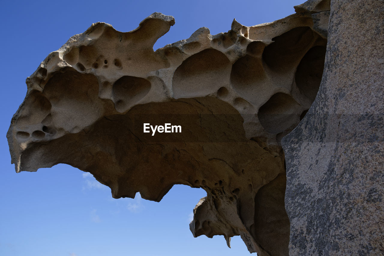 LOW ANGLE VIEW OF ROCK FORMATIONS AGAINST CLEAR SKY