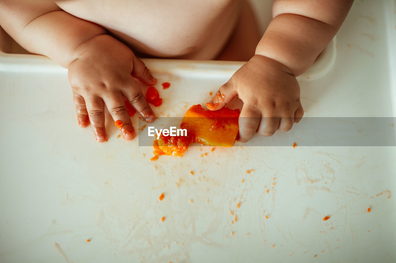 High angle view of baby with fruit on table