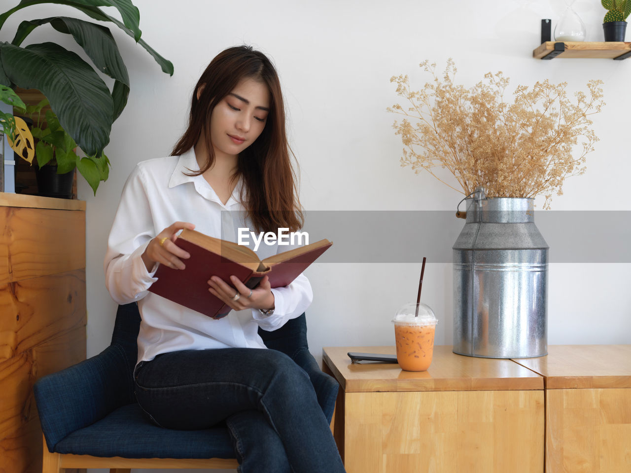 Young woman reading book while sitting at home