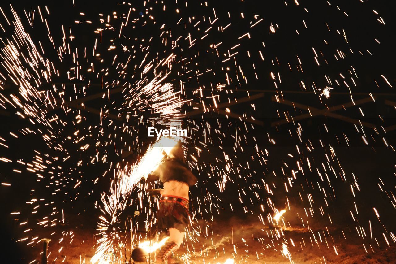 Person running by firework display at night