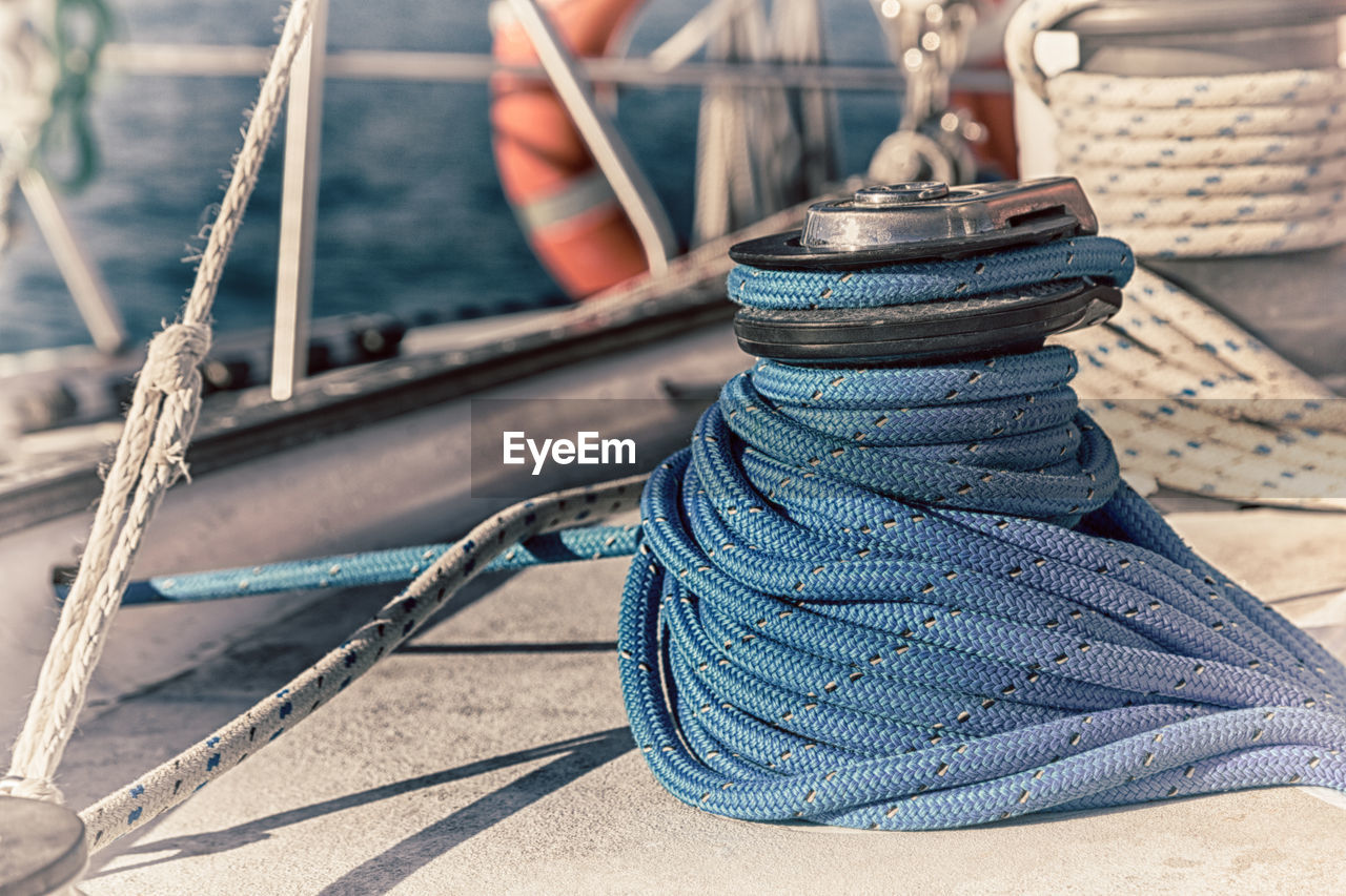 CLOSE-UP OF ROPE TIED TO BOAT