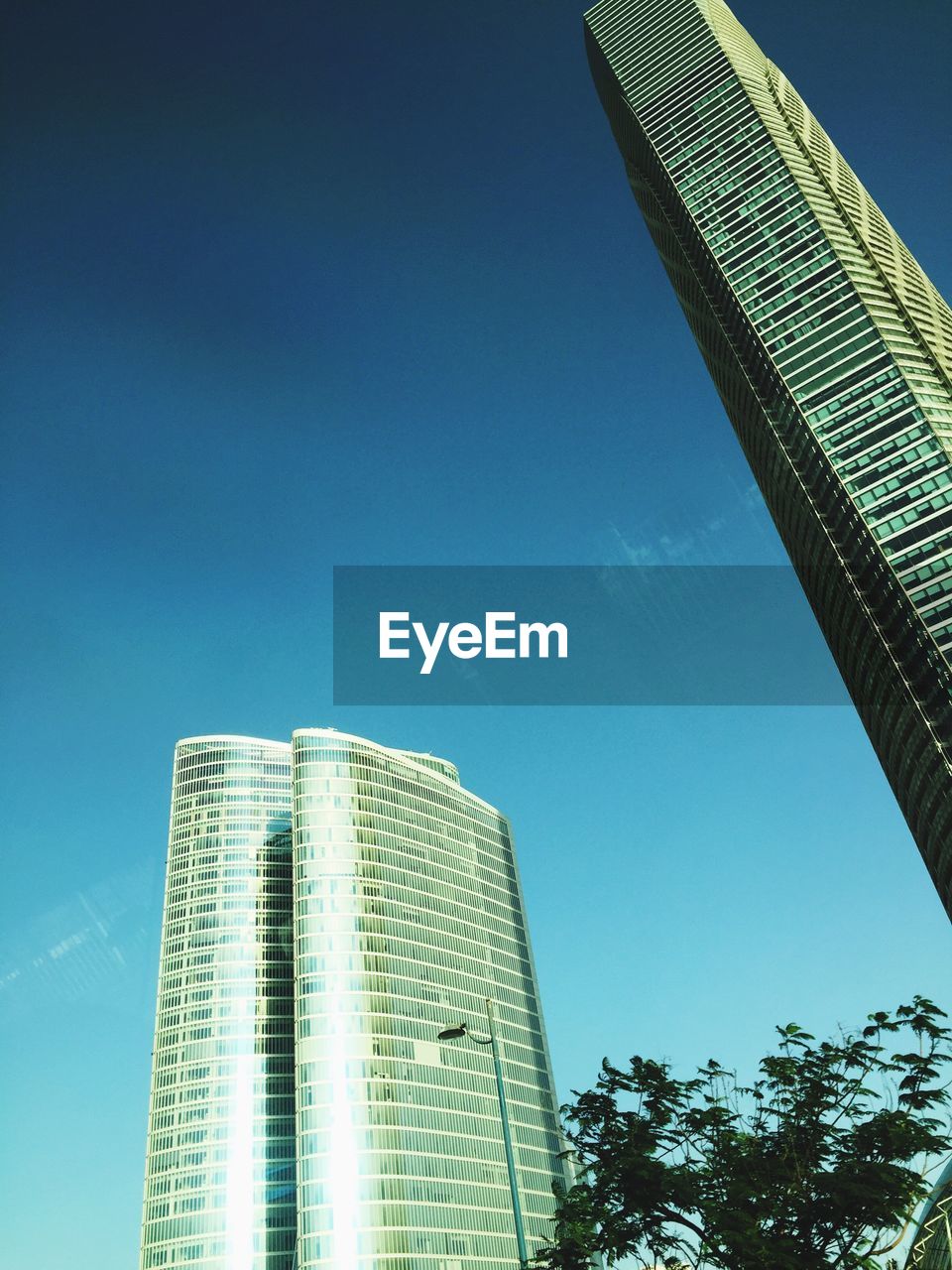 Low angle view of modern buildings against clear blue sky