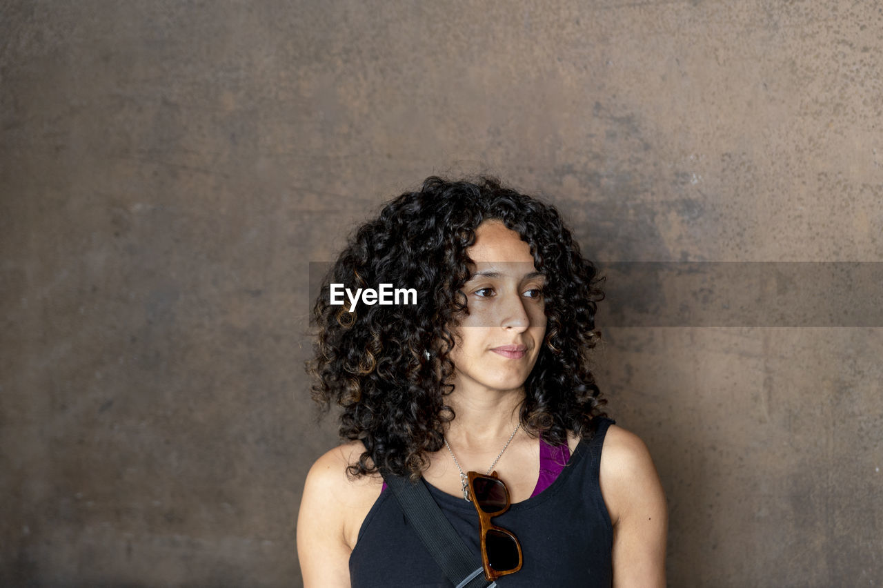 Portrait of a mixed race woman smiling while posing inside an abandoned factory.