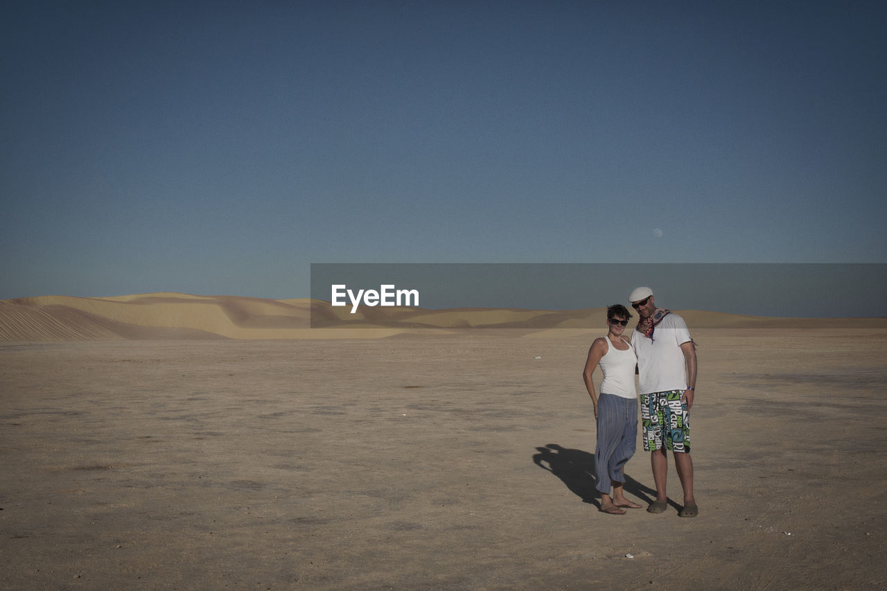 Portrait of couple standing at desert