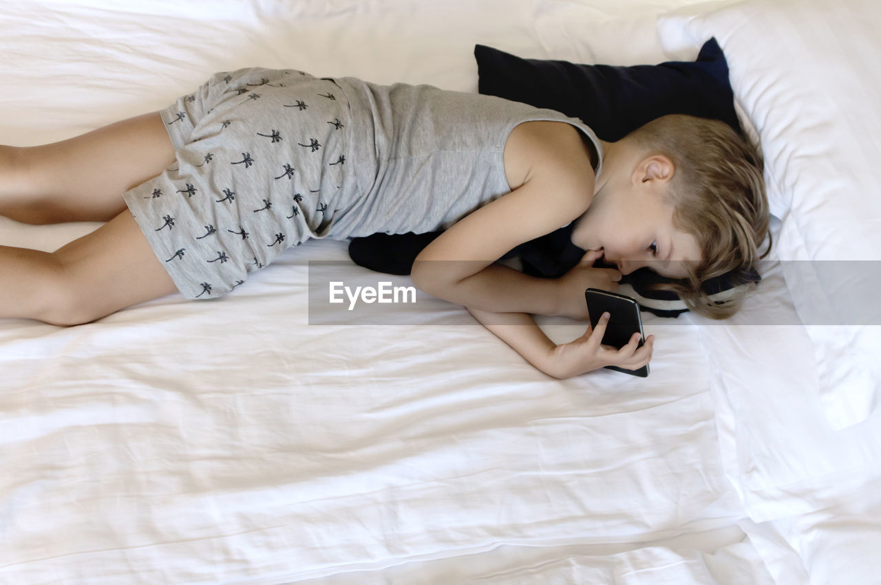 HIGH ANGLE VIEW OF WOMAN SLEEPING IN BED