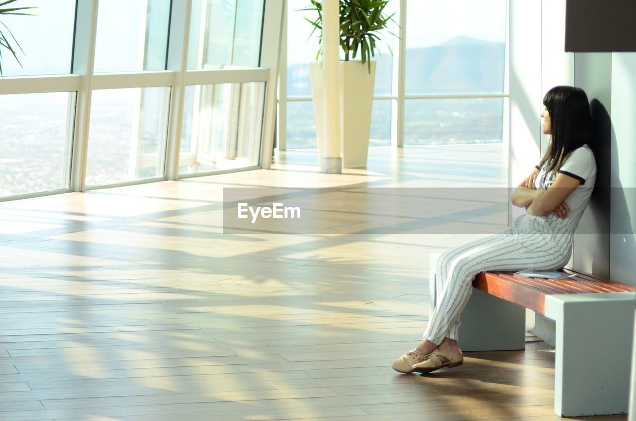 Side view of woman sitting alone, meditating.