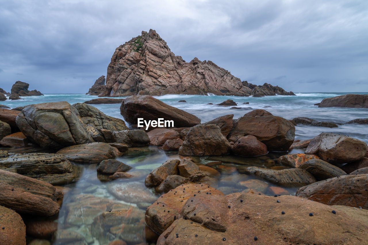 ROCKS ON SHORE AGAINST SKY