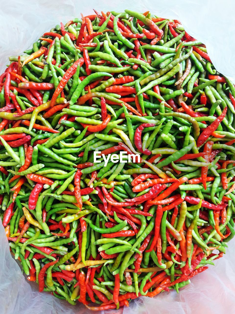 Directly above shot of green and red chili peppers at market stall