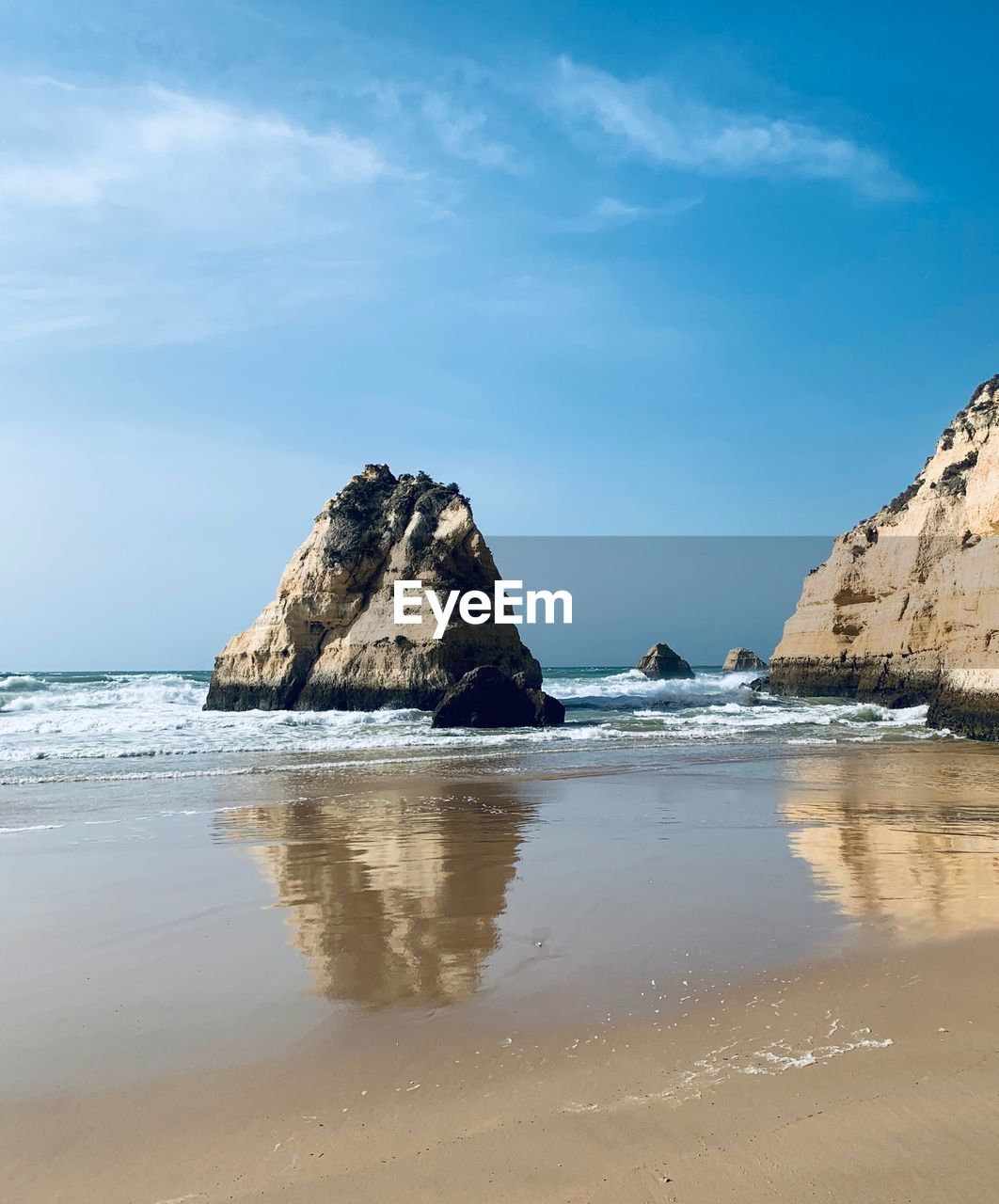 Rock formation on beach against sky